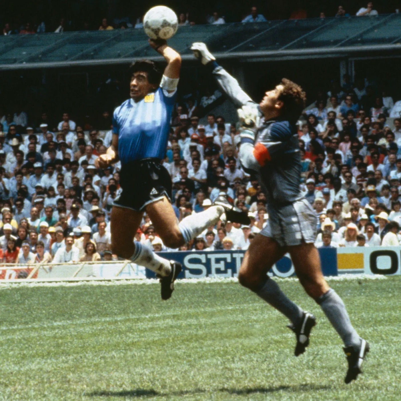 Diego Maradona leaping past the England goalkeeper at the 1986 World Cup.
